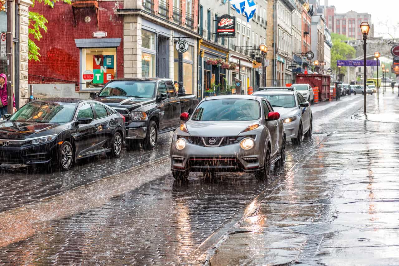 Quebec City, Canada – May 31, 2017: Old town street Saint-Jean during heavy rain with drops and wet road, car - Météo Québec : pluie, fraîcheur et grisaille pour la fête des Patriotes